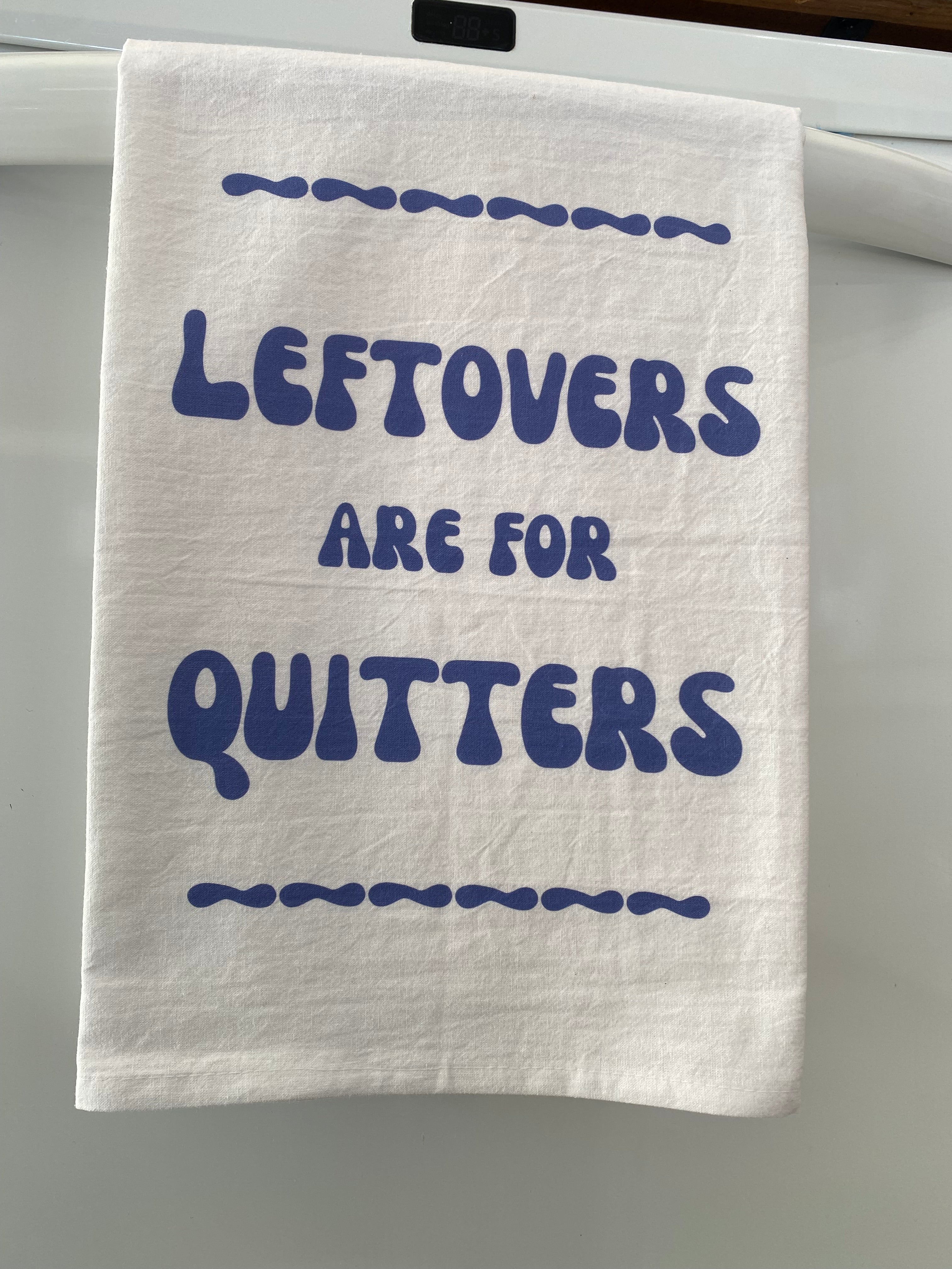White kitchen towel with Leftovers Are for Quitters in bold blue bubble lettering